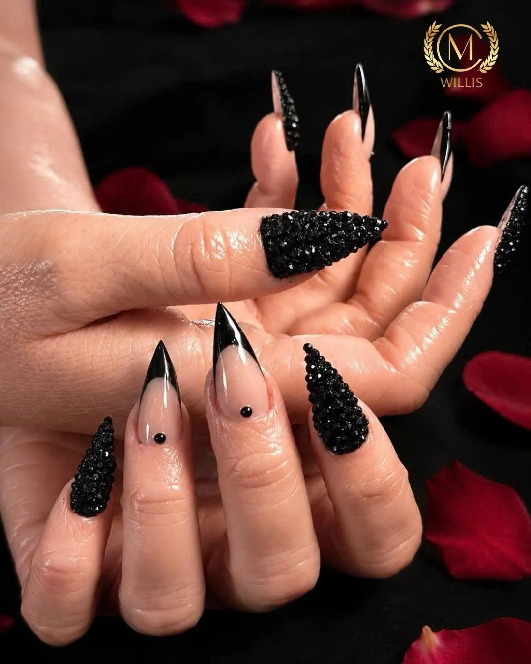 Black stiletto nails with crystal-encrusted accent nails and black French tips