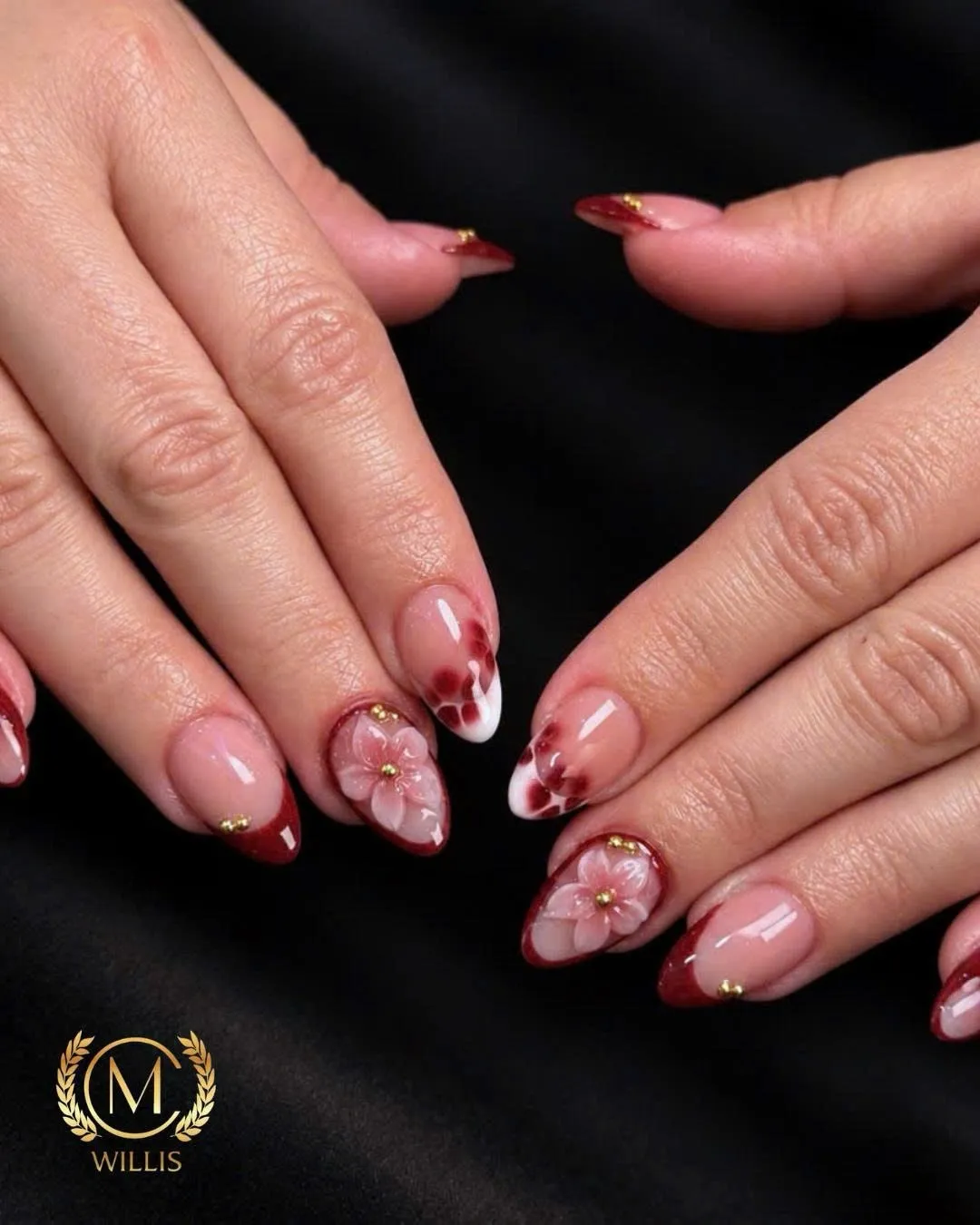 Almond nails with burgundy French tips, sculpted 3D flowers and gold studs