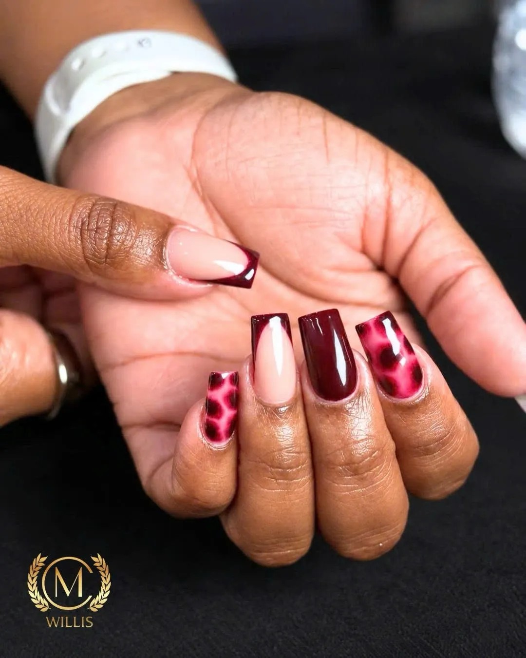 Square nails mixing deep burgundy, red leopard print and a red French tip