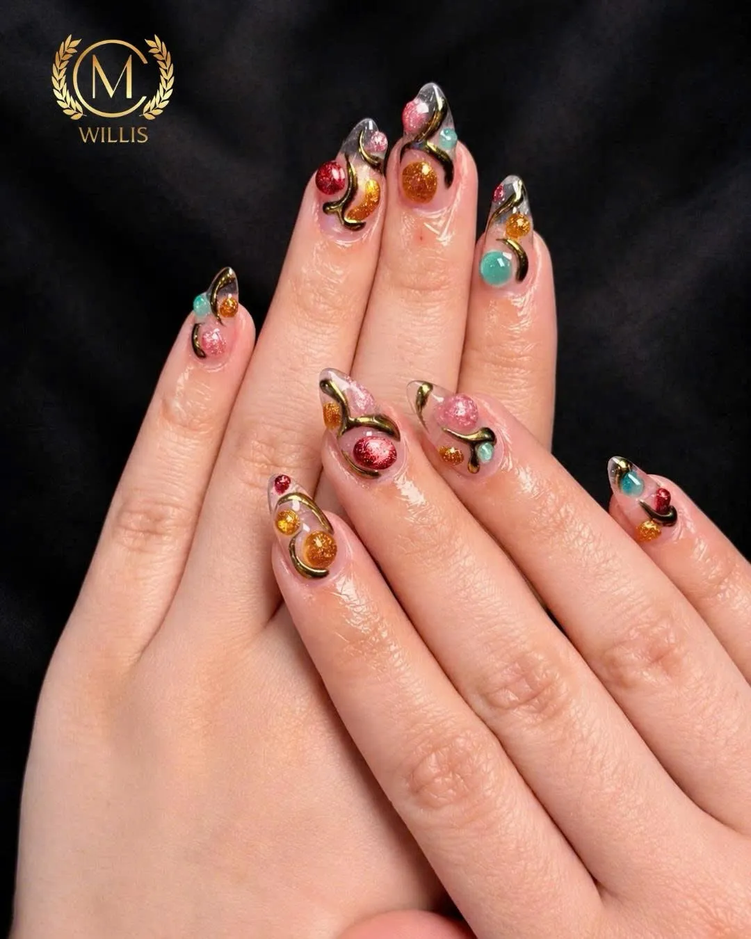 Clear almond nails with amber, teal and ruby 3D jelly beads outlined in gold swirls