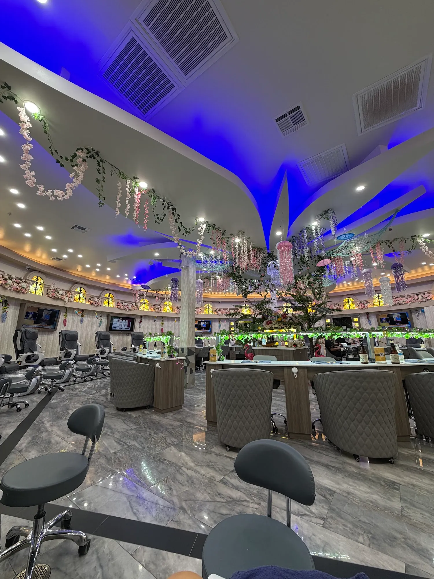 Blossom tree centerpiece surrounded by pedicure chairs on marble floors