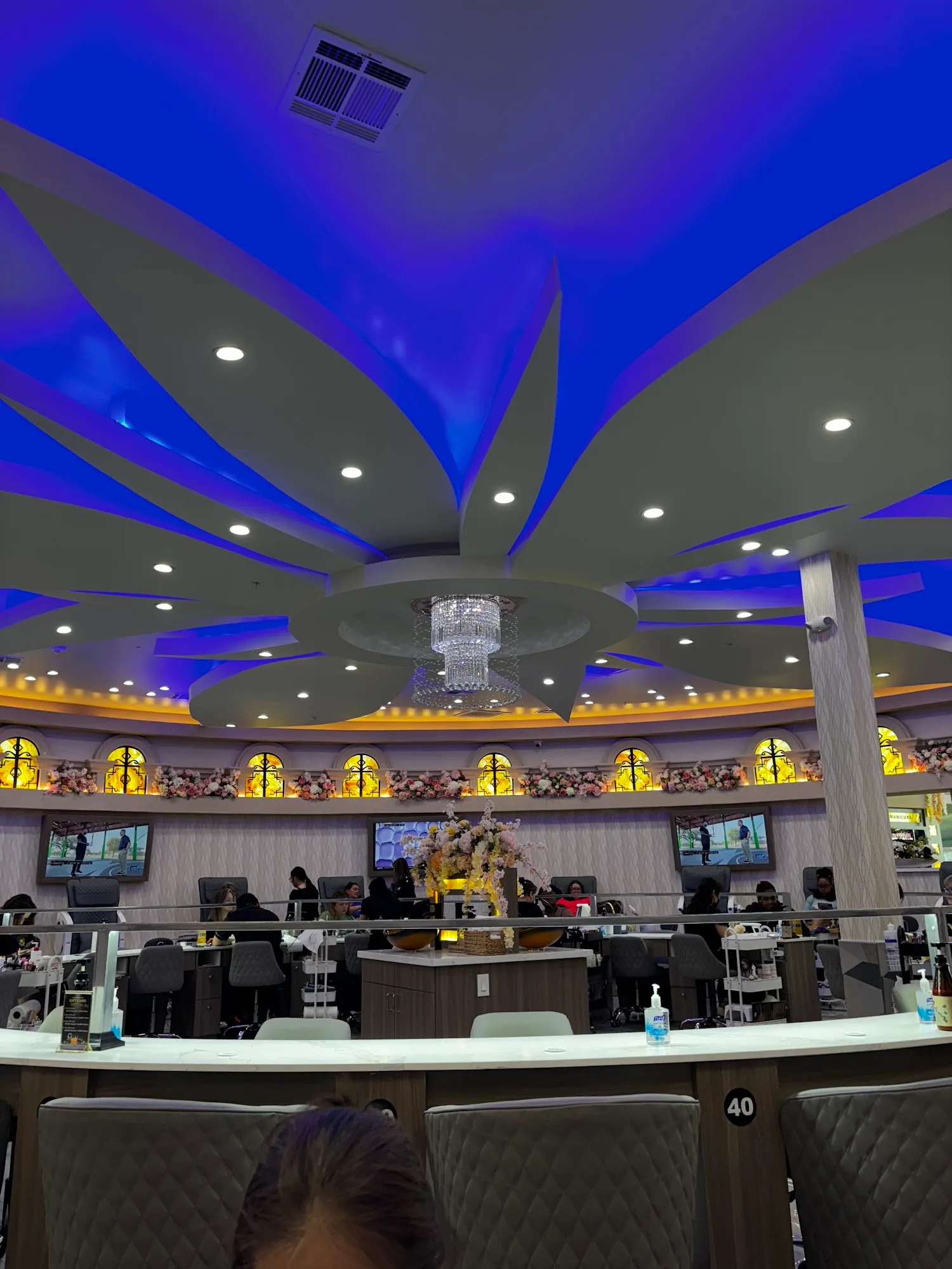 Manicure bar under a crystal chandelier at Milano Nail Spa Willis