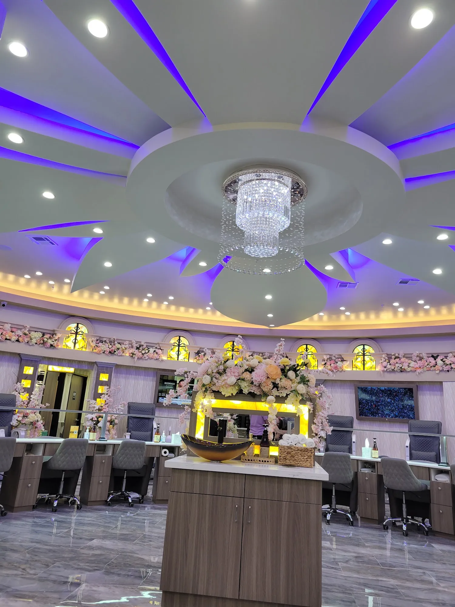 Crystal chandelier and blue-lit ceiling above the manicure bar