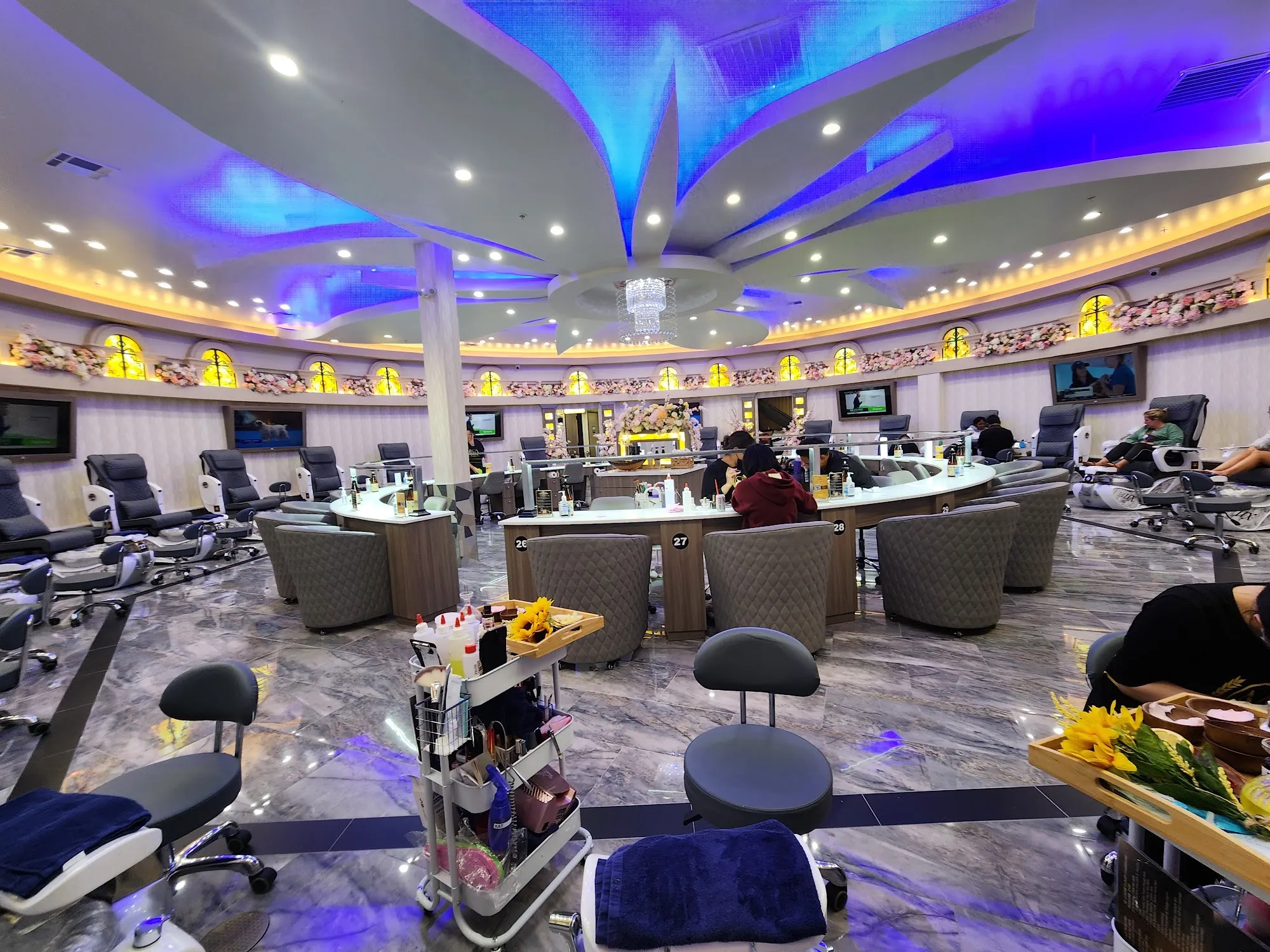 Pedicure lounge with spa chairs beneath the blue lit petal ceiling