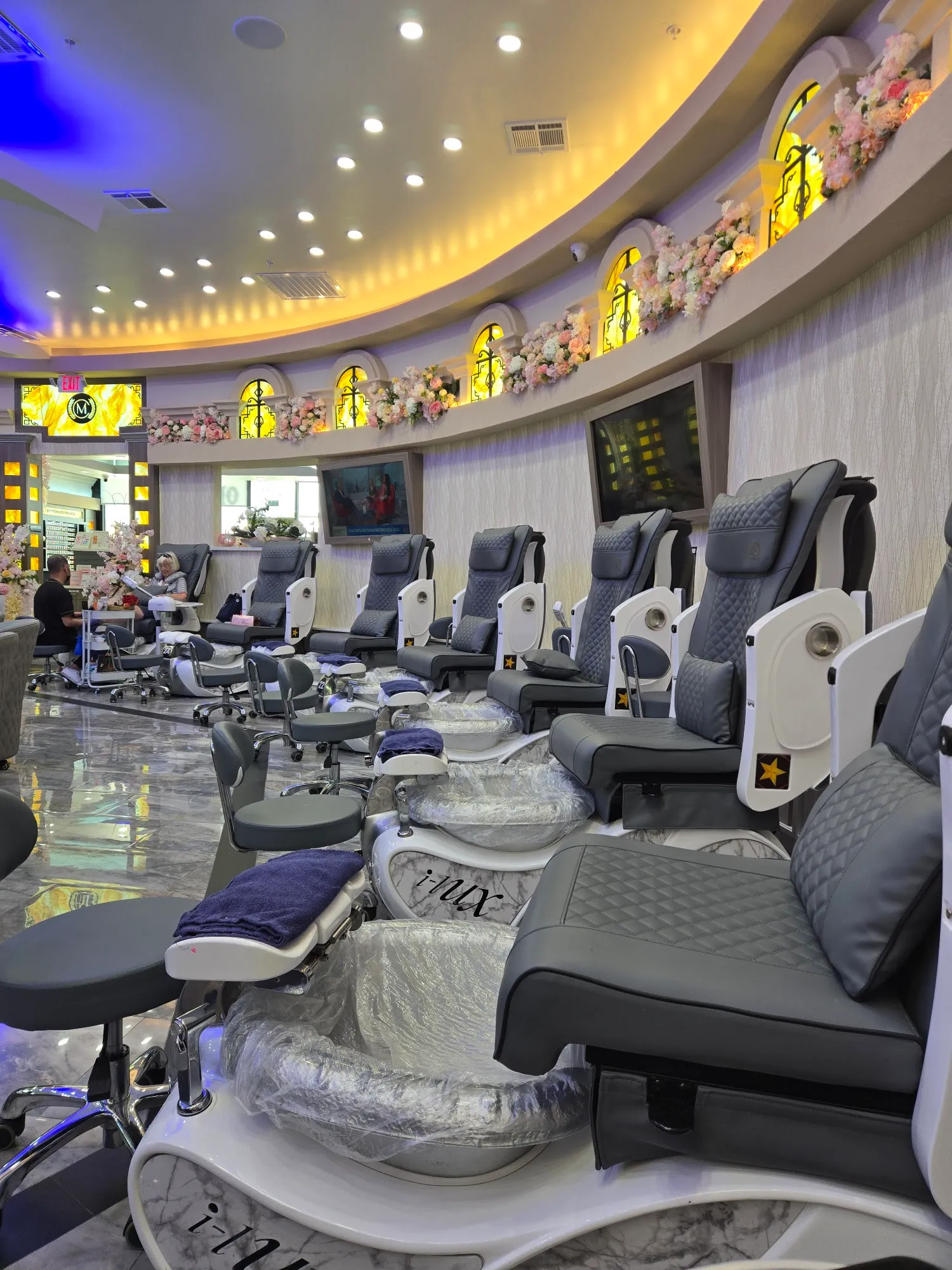 Row of cushioned pedicure spa chairs at Milano Nail Spa Willis