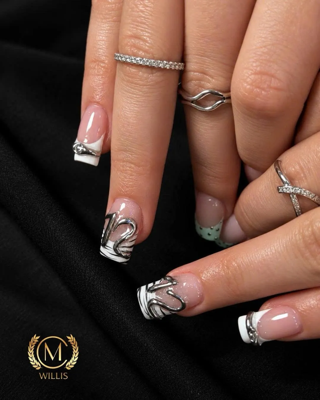 Short square nails with white French tips and raised silver chrome swirl accents